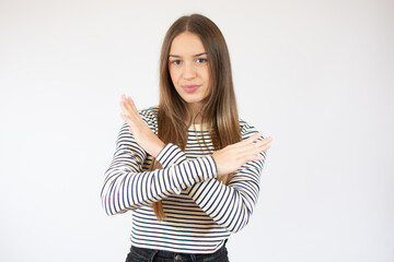 Beautiful girl wearing striped t-shirt against white wall Rejection expression crossing arms doing negative sign, angry face