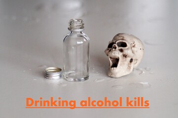 Teschio con bottiglia di alcol vuota sul tavolo. Simbologia delle conseguenze dell'alcolismo  