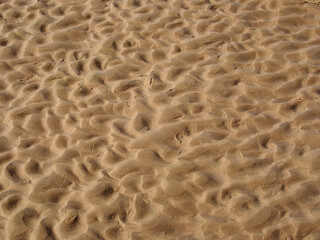 Fototapeta na wymiar close up or wet rippled sand on a beach at low tide