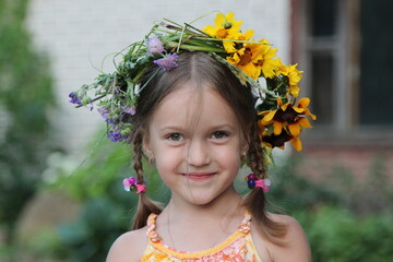 Smiling girl with wreath of flowers on her head