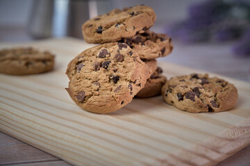 Chocolate cookies with a glass of milk and a jug of coffee on a wooden table