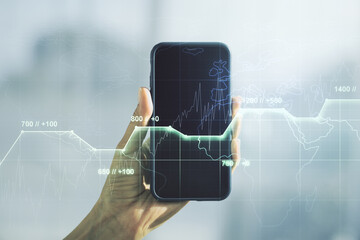 Multi exposure of creative statistics data hologram and hand with cell phone on background, stats and analytics concept