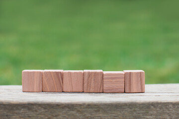 six empty wooden blocks  for own customer text or letters isolated on green nature background, banner copy space