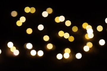 Blurred yellow christmas lights. Garland on dark background