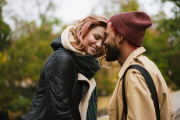 Fototapeta premium Multinational beautiful happy couple smiling while standing head to head