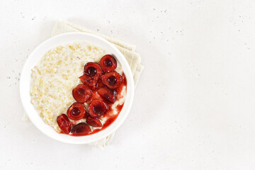 Healthy oatmeal porridge with cherry slices