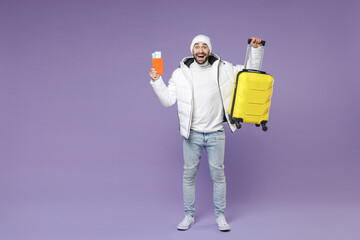 Full length of surprised traveler tourist man in white windbreaker jacket hat hold passport tickets...