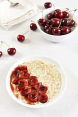 Oatmeal porridge with cherry slices in bowl