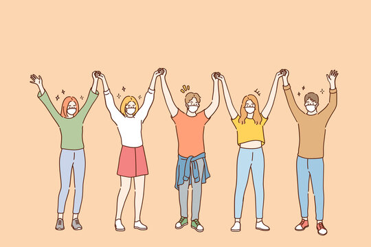 Friendship and having fun during COVID-19 pandemic concept. Group of young positive friends in protective medical face masks standing and holding raised hands in team during pandemic illustration 
