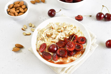 Healthy oatmeal porridge with cherry slices and nuts