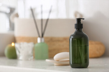 Green soap dispenser on white countertop in bathroom. Space for text