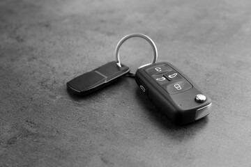 Modern car flip key with trinket on grey background