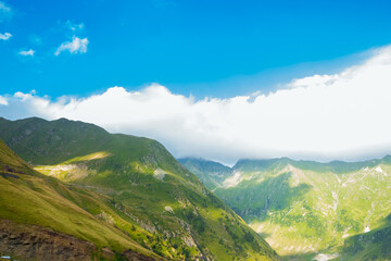 Romanian Carpathian mountains on a summer sunny day. Amaizing view on the mountains and cloudy sky from Transfagarasan alpine mountain road, Fagaras Mountains, Transylvania, Romania. Travel backdrop