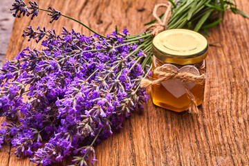 Obraz na płótnie Canvas Lavender essential oil, bunch of lavender flowers on wooden board
