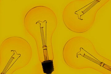 Close up image of a vintage filament light bulb on a yellow
