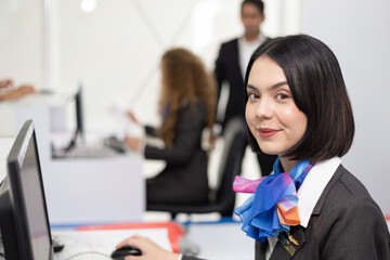 Portrait of beautiful attractive woman officer smiling look at camera sitting at check in counter desk at the airport. business airline service concept. copy space