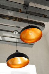 Hanging lamps are attached to a wooden ceiling in a loft style
