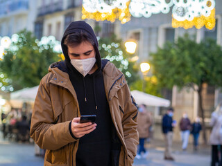 Obraz premium Hombre joven usando su teléfono móvil durante el invierno 