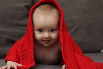 Close-up portrait of cute baby girl in red blanket