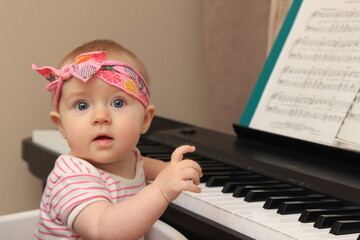 Small baby girl playing piano