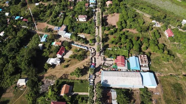 Aerial drone footage over a small village in Koh Okhna Tey island , green , nature and houses from the sky