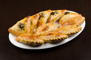 meat pies, samsa, samsa, traditional asian food 
in a white plate on a wooden background