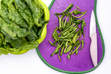Fresh chopped spinach on a cutting board. Juicy green spinach, white background