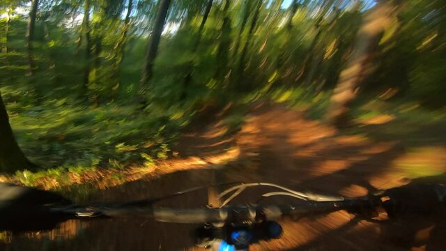 Speed downhill mountain bike riding in a forest. View from first person perspective POV.