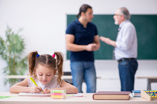 Young Parent, Old Male Teacher And Little Girl In The Classroom