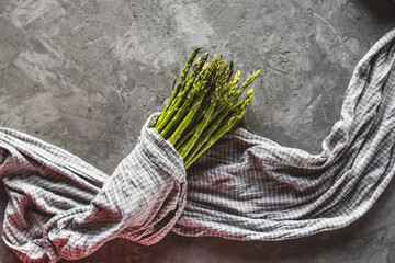 Asparagus in a kitchen towel on a gray background. healthy food - 400781098