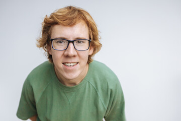 portrait of a red-haired man with glasses on a light background