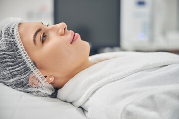 Dreamy patient in a gauze cap looking away