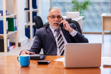 Old businessman employee working in the office