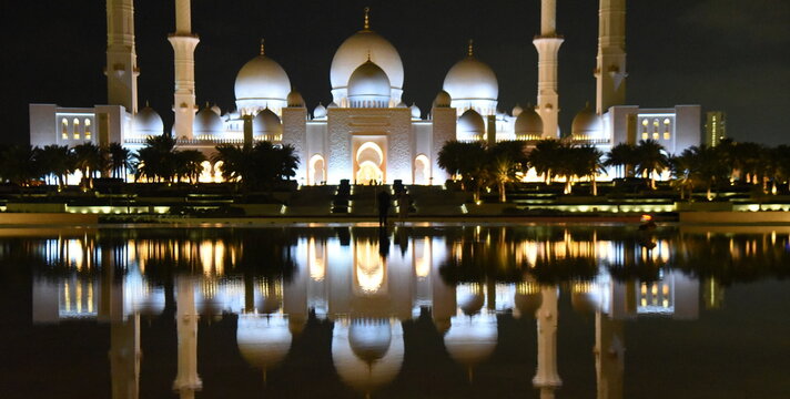 Spiegelung der n&auml;chtlich beleuchteten Scheich-Zayid-Moschee auf blanker Wasseroberfl&auml;che