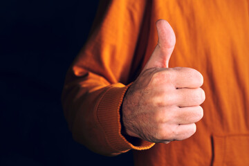 Low key male thumbs up hand gesture