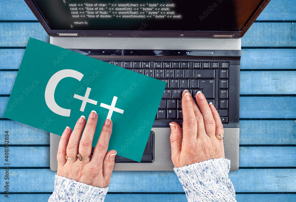 Poster c++ programing language . woman hands on laptop and word c++ on paper sheet