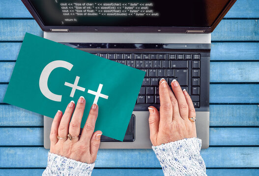 c++ programing language . woman hands on laptop and word c++ on paper sheet

