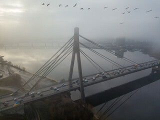 Aerial drone view. North bridge in Kiev, shrouded in morning fog. Seagulls fly over the bridge.