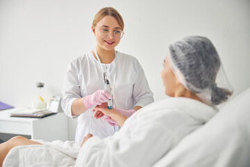 Friendly young dermatologist conducting a cosmetic procedure