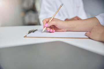 Female doctor taking notes about her patient