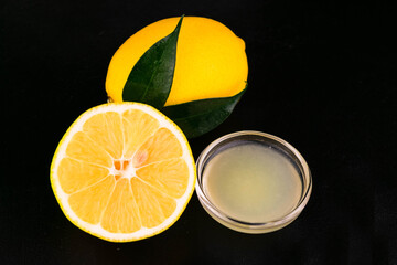 
Lemon juice and fresh lemon on a black background.
Close-up.