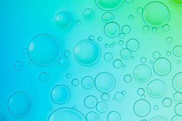 Creative neon background with drops. Glowing abstract backdrop with vibrant gradients on bubbles. Blue, turquoise and green white overflowing colors