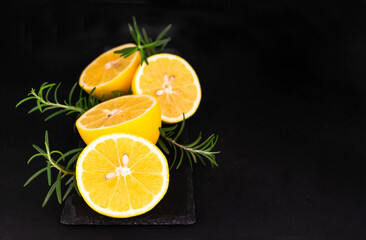Fototapeta na wymiar Fresh sliced ​​in half lemons on black background. Copy space.