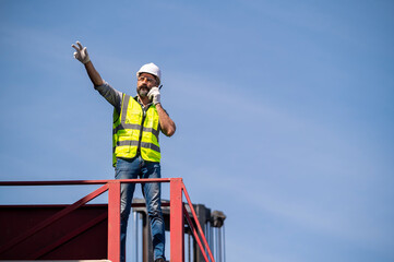 Logistics engineer stand on and Pointing up around Shipping container stacker in commercial transport port