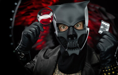 a man wearing a demon skull mask in a leather cloak with a magnifying glass and pills - doctor evil