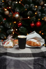 Christmas coffee and croissants with gifts and toys on the background of the Christmas tree