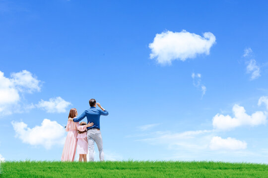 Happy Parents With Daughter Looking At Blue Sky