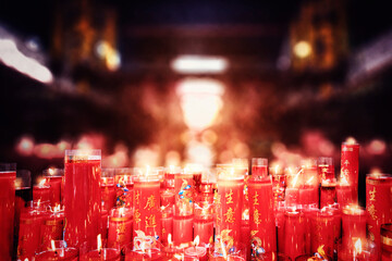 Rows of big burning Chinese red candles at temple