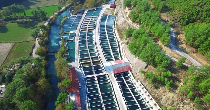 aerial drone footage of fish farm on a river between mountains mediterranean turkey agriculture