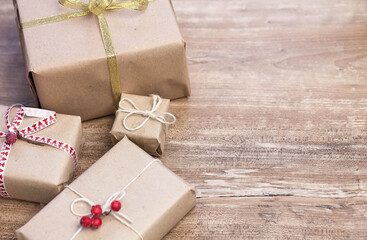 Christmas gift boxes and glowing garland on wooden background. New Year presents.